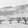 17.01.1909. Nord-Fron. Vinterparti ved Sundbroen og N. Byhre. Islagt elv, bro, bolighus, uthus, fjellformasjoner.