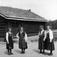 Verter i drakter foran stua fra Nedre-Jorde, bygning nr. 111 i Hallingdalstunet Norsk Folkemuseum.