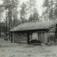 Follandsvangen, Alvdal, Nord-Østerdal, Hedmark. Seterhus mellom høye trær. Nå på Glomdalsmuseet.