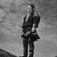 Mikkel Per Kemi i kautokeino-drakt står på fjellet.  Finnmark 1958.