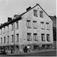Stolmakergata 8, Oslo 1961. Fasaden, barn står lent mot gatehjørnet, biler parkert ved fortauet.