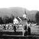 Eggedal kirke, Sigdal, Buskerud. 1930. Landskap. Kornstaurer og gravsteiner. Skog og fjell i bakgrunnen.