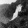 Landskap, Espelandsfossen, Granvin, Hardanger, Hordaland. Veiparti med to menn i forgrunnen.
Del av gave fra Den norske Turistforening 1972.