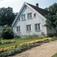Eksteriøret på Søgne prestegård. Byste av Bjørnstjerne Bjørnson i hagen.