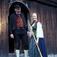 Verter  i Østerdalsdrakter foran Barfrøstua, bygning nr.151, Østerdalstunet på Norsk Folkemuseum.Heidi holder en lur.