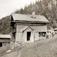 Gårdstun med gammel stuebygning, Skaarberg, Tinn, Telemark. Kvinne, mann og jente foran huset. Fotografert 1907.
