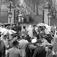 Fra Oslo,17.05.1963. Sammenstimling av folk foran en port for å se toget forsvinne opp en allé på 17. mai i regnværet.