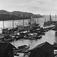 Moderna bryggor och fiskebåtar mot en förgrund av traditionellt utformade sjöbodar
