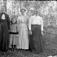 Gruppfoto av tre kvinnor och en flicka i det gröna från början av 1900-talet.