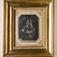 Porträtt av äldre, okänd dam. Klädd i mörk klänning med vita spetsmanschetter och vit spetskrage, rutig sjal samt vit spetsmössa. Dagerrotyp / daguerreotyp i glas och förgylld ram. Nordiska museet inv.nr 190361.